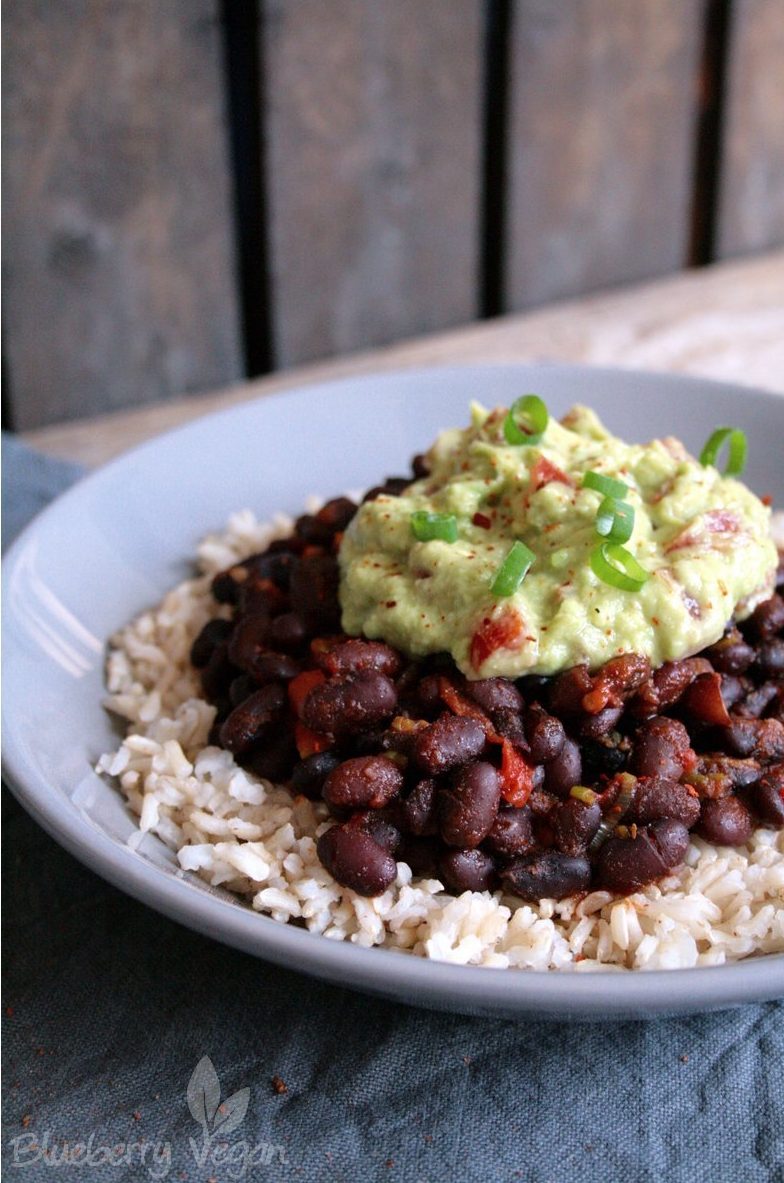 Sättigende Burrito Bowl mit Reis, schwarzen Bohnen und Guacamole